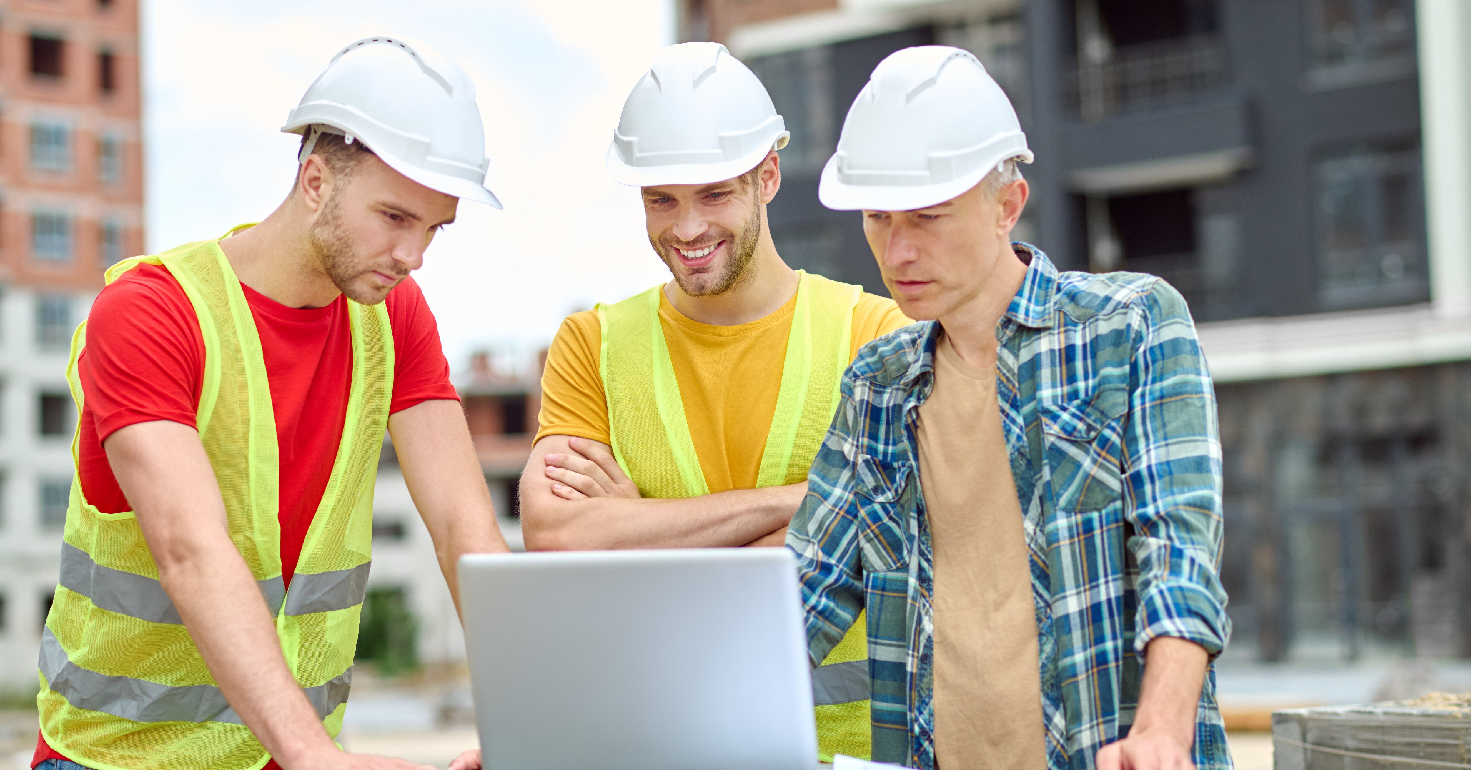 Construction team looking at a laptop on commercial site