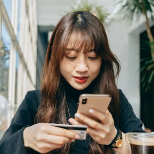 Teenager using her phone and debit card