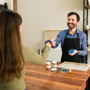 how can businesses solve economic problems Small business owner receiving payment method
