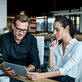 Two small business owners examining their point of sale system on a tablet