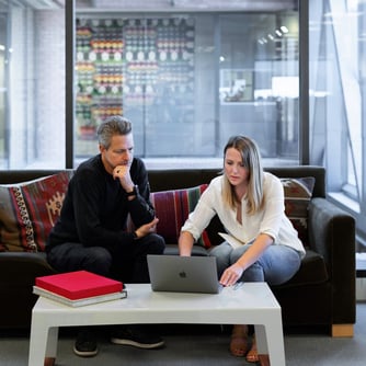 Small business owners investing into a CD account, working from laptop on couch