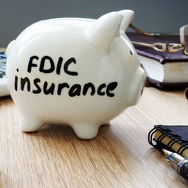 Glass piggy bank with FDIC Insurance written on the side