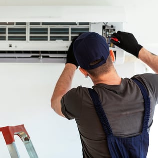 Repairman fixing a broken HVAC unit