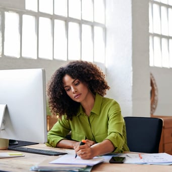 Small business owner reviewing finances at her desk