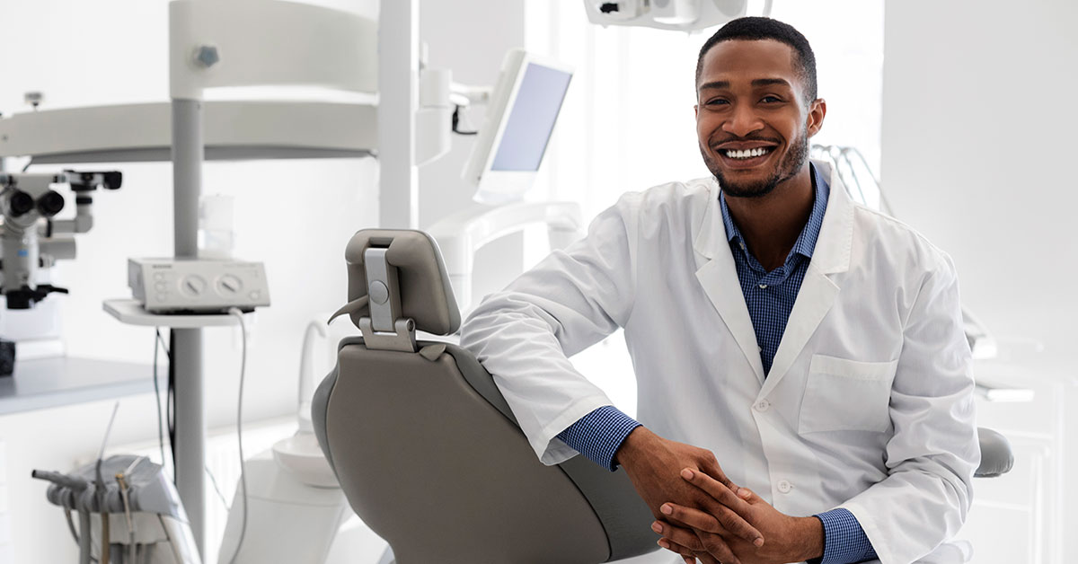 Small business owner dentist smiling in front of his office 