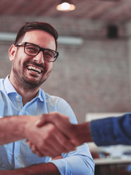 Male business owner shaking hands with someone.