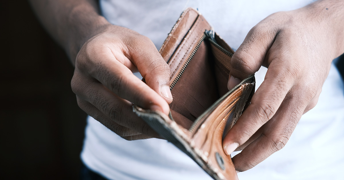 Small business owner looking into an empty leather wallet