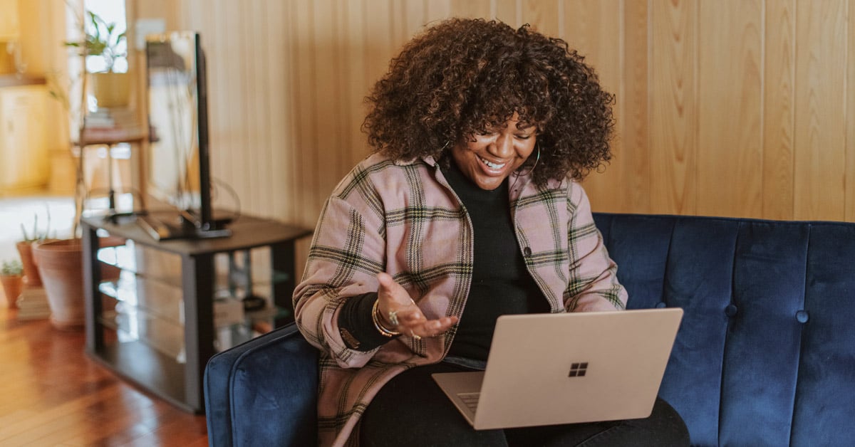 Woman typing at her laptop, enthusiastically