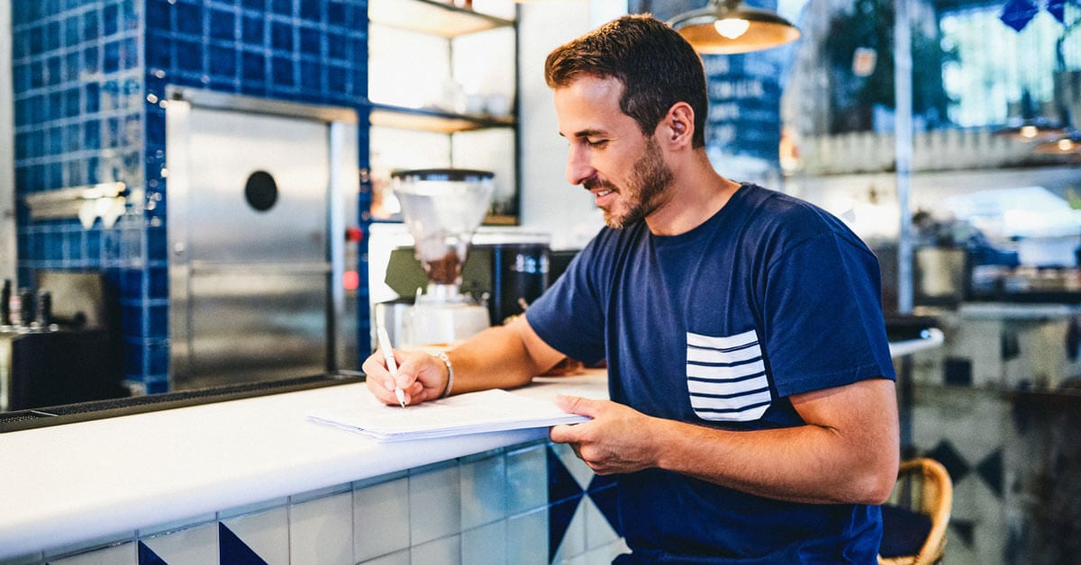 Business owner sitting at the counter of his establishment 