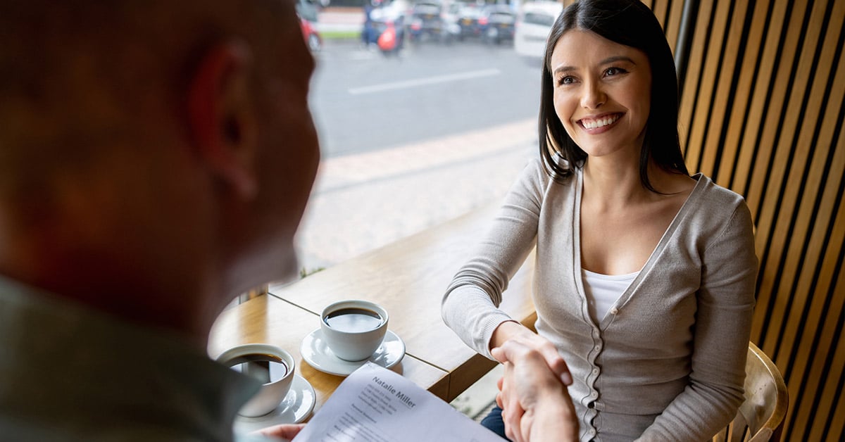 Business owner shaking hand with potential employee during interview